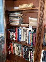 Photo of wooden shelves filled with a large number of books and magazines primarily on trains, railroads, and related topics.