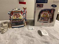 Photo showing ceramic bandstand, power adapter, information card, and original box.