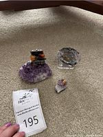 Photo showing all three geode decorations on carpeted floor with auction lot tag visible