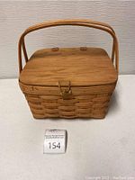 Longaberger pie basket closed with wood insert lid and handle visible from front.