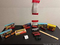 Overview of train parts displayed on black surface with some packaged boxes.