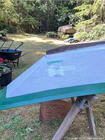 White deck and green trim on hull turned upside down on sawhorses