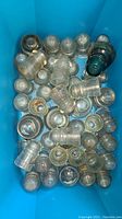 Top view of a large collection of mixed glass insulators in various sizes and colors mostly clear with some teal.