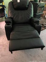 Full view of black reclining chair extended with footrest visible, cup holders on each armrest.