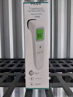 Photo of front packaging of forehead thermometer showing model FC-IR202 and digital display with reading 98.6°F.