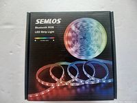 Closed retail box of Semlos Bluetooth RGB LED strip light showing product image and RGB color spectrum.