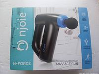 Box showing the Njoie N-Force massage gun on front with product features including deep tissue massage, 3 speed settings, improved circulation and workout recovery.
