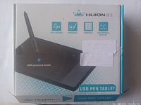 Front of the box showing Huion USB pen tablet, pen image, 2048 pressure levels, and usage icons for signing, drawing, and writing.