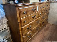 Side angled view of the dresser showing top and larger drawers with metal handles.