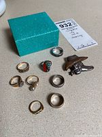 All nine pieces arranged on countertop next to box and lot tag