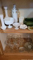 Shelf upper with various milk glass vases, candy dish, and cut glass pieces and lower shelf with set of six wine glasses and cut glass bowl with heart design