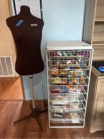 Mannequin and metal rack loaded with sewing supplies