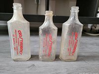 Three vintage pharmacy bottles standing upright with red silk screen printing from Crosthwaite's Pharmacy St. Marys Ontario.