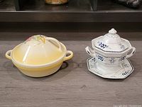 Front view showing the yellow gradient Susie Cooper vegetable bowl with floral design alongside the hexagonal white Adams England individual tureen with blue floral patterns and matching underplate.