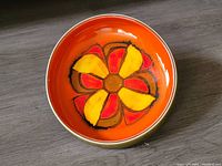 Photo showing top view of the console bowl with vibrant orange interior and floral design