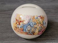 Front view showing detailed Bunnykins illustration of bunnies in nursery setting on ceramic bank.