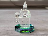 Clear facet cut crystal castle figurine on a multicolored faceted base showing prismatic colors with light reflections