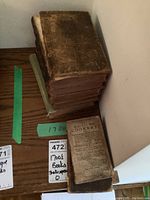 Stack of seven leather-bound books on wooden surface
