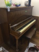 Angled frontal view of piano and bench showing overall condition