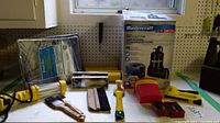 Photo of Mastercraft pool utility pump box, handheld utility light, paint brushes, scraper, brush holder cup, Stanley stapler, and screwdriver set on workbench.