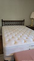 Assembled queen mattress on wood bedframe showing overall lot