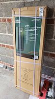 Photo showing the unopened boxed Yukon Gear gun cabinet with product label and dimensions (14" x 17" x 53").