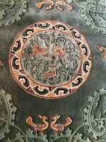 Close-up of central medallion with stylized animal figures and scrollwork