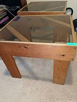 Front and side view of one wooden side table with glass top, showing clear visible wood grain, knots, and inset glass surface
