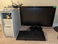 Photo shows the computer tower, Samsung 27-inch monitor, wired keyboard, and wired mouse arranged on a desk.