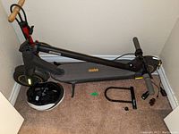 Full view of scooter folded and accessories on floor.