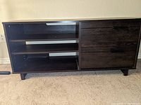Front view of the dark wood TV stand showing open shelving on left and two drawers on right.