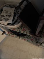 Image showing black griddle or indoor grill with instruction manual on white wire rack.