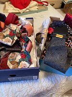 Photo showing two boxes of men's ties with varied colors and patterns including a Cuft & Barrow Paisley tie new with tag.