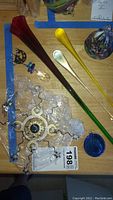 Top view of various glass suncatchers and window hanging decorations arranged on a wooden surface with a blue tape border.