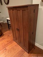 Side angle view of the laminate wood cabinet showing the depth and door design.