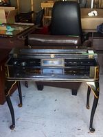 Front view of vintage Asian themed wooden desk with top flipped open showing small drawer and storage.