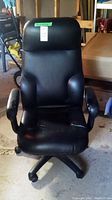 Front view of black Global office chair showing padded seat, back, and armrests with some visible wear and damage on seat.