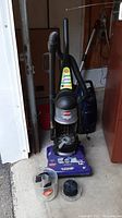 Front view of Bissell Powerforce bagless vacuum cleaner and accessories on the floor showing brand and model details.