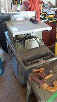 Rubbermaid plastic utility cart under table saw (table saw not included) showing overall cart shape and wheels