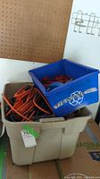 Overview of beige and blue storage bins containing orange extension cords, ratchet straps, and other electrical components.
