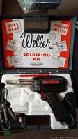 Full view of the Weller soldering kit in original case showing the gun, two tools, and packaging graphics.