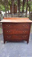 Front view of the vintage wooden dresser showing three drawers with metal pulls and refinished top surface
