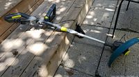 Full view of the Yardworks battery powered string trimmer showing trimmer head, shaft, and handle.