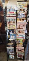Photo of cooking and home how-to books arranged in a rack, titles clearly readable showing variety of cookbooks and home guide books.