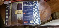 Packaging of long garment bag showing fabric-like material and blue and white checkered pattern