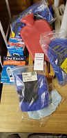 Photo showing the red rubber water bag, OneTouch UltraMini blood sugar monitor kit in box, blue gel packs, blue knee wrap, ace bandage, and blue arm sling.