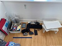 Overview of lot showing multiple folders, notepads, books, cameras, keyboard, cables, and trays on the floor.