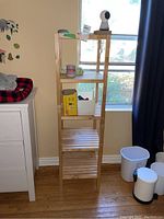 Full view of the shelving unit in a room setting near a window with some items temporarily placed on the shelves.