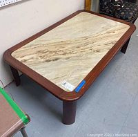 Full view of a rectangular marble top coffee table showing the marble and wooden frame.