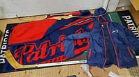 Photo showing Patriots fleece blanket, windbreaker jacket, and hockey stick
